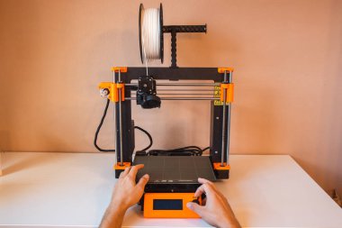 Yeni şeyler yapmak için teknolojik teg aleti. Siyah ve kırmızı 3D yazıcı iş başında. Nesne, madde katmanlarının katmanlarını katma süreçlerine yerleştirerek oluşturulur...
