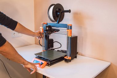 Yeni şeyler yapmak için teknolojik teg aleti. Siyah ve kırmızı 3D yazıcı iş başında. Nesne, madde katmanlarının katmanlarını katma süreçlerine yerleştirerek oluşturulur...