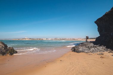 Portekiz 'in batısındaki Odemira bölgesinde Praia das Furnas manzarasının tadını çıkaran sırt çantalı yaşlı bir adam. Balıkçı Patikası boyunca gezinen, Rota Vicentina.