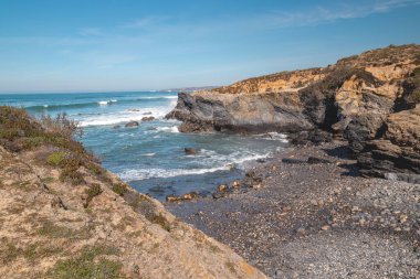 Portekiz 'in batısındaki Odemira bölgesinde güneşli bir günde Atlantik kıyısında nefes kesici kayalık bir ortam. Balıkçı Patikası boyunca gezinen, Rota Vicentina.