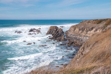 Portekiz 'in batısındaki Odemira bölgesinde, Zambujeira do Mar' daki Atlantik Okyanusu 'ndan yükselen kayalıkların manzarası. Balıkçı Patikası boyunca gezinen, Rota Vicentina.