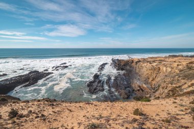 Portekiz 'in batısındaki Odemira bölgesindeki Atlantik Okyanusu' ndan yükselen kayalıkların manzarası. Balıkçı Patikası boyunca gezinen, Rota Vicentina.