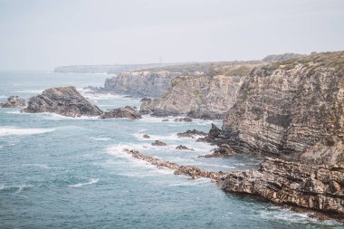 Portekiz 'in batısındaki Odemira bölgesinde, Zambujeira do Mar' daki Atlantik Okyanusu 'ndan yükselen kayalıkların manzarası. Balıkçı Patikası boyunca gezinen, Rota Vicentina.