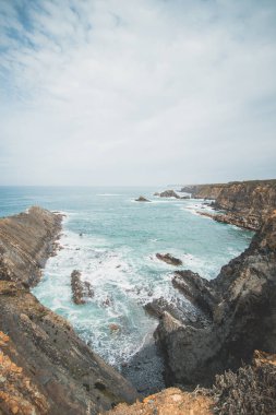 Portekiz 'in batısındaki Odemira bölgesinde, Zambujeira do Mar' daki Atlantik Okyanusu 'ndan yükselen kayalıkların manzarası. Balıkçı Patikası boyunca gezinen, Rota Vicentina.