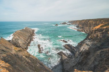 Portekiz 'in batısındaki Odemira bölgesinde, Zambujeira do Mar' daki Atlantik Okyanusu 'ndan yükselen kayalıkların manzarası. Balıkçı Patikası boyunca gezinen, Rota Vicentina.
