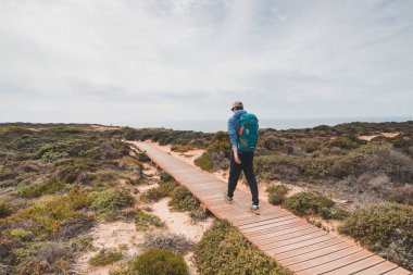 Genç ve cesur Serseri Portekiz kırsalında dolaşıyordu. Bir sırt çantası Portekiz 'in Odemira bölgesinde ahşap bir yürüyüş yolu boyunca yürüyor. Balıkçı Yolu, Rota Vicentina.