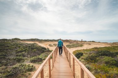 Genç ve maceracı Serseri Portekiz 'in Balıkçı Patikası' ndaki kırsalında gezinirken Atlantik Okyanusu manzarasının tadını çıkarıyor. Odemira bölgesi, Rota Vicentina.