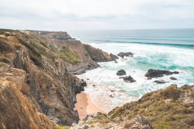 Portekiz 'in Odemira bölgesindeki Atlantik Okyanusu' nun dalgalarıyla sulanan sarı-turuncu kumlara sarp kayalıklar düşüyor. Balıkçı Yolu 'nun ayak izlerinde, Rota Vicentina..