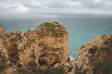 Portekiz 'in Algarve bölgesindeki Lagos yarımadasının güneyindeki Ponta da Piedade adlı ünlü turizm merkezi. Öğleden sonra boyunca sarı-altın uçurumların pelerini.