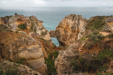 Portekiz 'in Algarve bölgesindeki Lagos yarımadasının güneyindeki Ponta da Piedade adlı ünlü turizm merkezi. Öğleden sonra boyunca sarı-altın uçurumların pelerini.