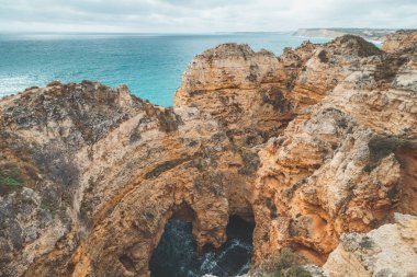 Portekiz 'in Algarve bölgesindeki Lagos yarımadasının güneyindeki Ponta da Piedade adlı ünlü turizm merkezi. Öğleden sonra boyunca sarı-altın uçurumların pelerini.