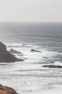 Portekiz 'in Odemira bölgesindeki kayalık kayalıklardan ve kumlu plajlardan oluşan batı kıyı şeridi. Yağmurlu günlerde Balıkçı patikasında dolaşmak.