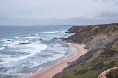 Portekiz 'in Odemira bölgesindeki kayalık kayalıklardan ve kumlu plajlardan oluşan batı kıyı şeridi. Yağmurlu günlerde Balıkçı patikasında dolaşmak.