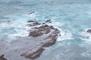 Portekiz 'in güneybatısındaki Aljezur kasabası yakınlarındaki Atlantik kıyısında fütürist desenli kayalıklar. Güneş batarken okyanusun sesi. Rota Vicentina 'da dolaşıyorum..