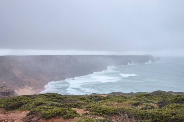 Portekiz 'in güneybatısındaki Algarve bölgesindeki kayalık uçurumlarda fırtınalı bir hava var. Okyanusun gücü. Balıkçı yolunda gezinen, Rota Vicentina.