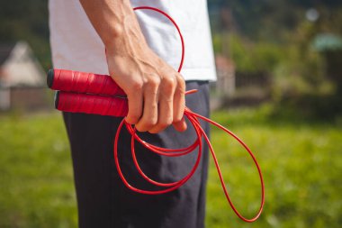Kahverengi saçlı, atletik yapılı bir çocuk, atlama halatını dayanıklılığı ve atlama gücünü arttırmak için en iyi araçlardan biri olarak tanıtıyor..