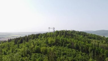 Çek Cumhuriyeti 'nin doğusundaki iki kuleye bakan Hranicni Vrch kulesinin hava görüntüsü. Tepenin tepesinde güçlendirilmiş beton gözetleme kulesi. 4k video