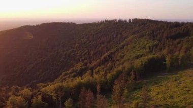 Nefes kesen bir gün batımının hava görüntüsü turuncu ışığıyla çevresini aydınlatıyor. Yürüyüş yaşam tarzı. 4k video