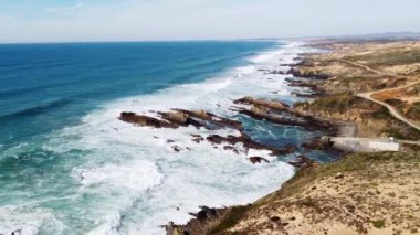 Portekiz 'in batı kıyısında kumlu plajlar ve yumuşak ışıkla kumu ısıtan temiz bir Atlantik Okyanusu var. Algarve Bölgesi. Plajda tatiller. 4k video