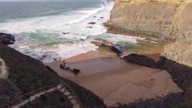 Portekiz 'in batı kıyısında kumlu plajlar ve yumuşak ışıkla kumu ısıtan temiz bir Atlantik Okyanusu var. Algarve Bölgesi. Plajda tatiller. 4k video