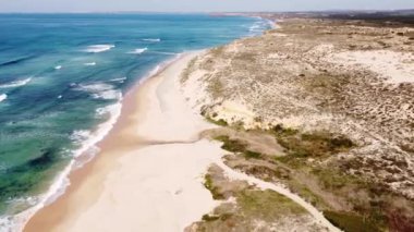 Portekiz 'in batı kıyısında kumlu plajlar ve yumuşak ışıkla kumu ısıtan temiz bir Atlantik Okyanusu var. Algarve Bölgesi. Plajda tatiller. 4k video