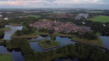 Hollanda 'nın tarihi Naarden kasabasında şafak söküyor. Kasabanın etrafında yıldız şeklinde kanallar var. Gün doğumu. 4k video