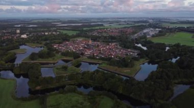 Hollanda 'nın tarihi Naarden kasabasında şafak söküyor. Kasabanın etrafında yıldız şeklinde kanallar var. Gün doğumu. 4k video