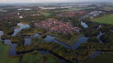 Hollanda 'nın tarihi Naarden kasabasında şafak söküyor. Kasabanın etrafında yıldız şeklinde kanallar var. Gün doğumu. 4k video