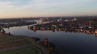 Güneş doğarken Zaanse Schans 'ın eski ahşap yel değirmenleri. Altın ışınlar Hollanda 'nın tarihini gözler önüne seriyor. 4k video