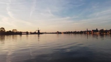 Güneş doğarken Zaanse Schans 'ın eski ahşap yel değirmenleri. Altın ışınlar Hollanda 'nın tarihini gözler önüne seriyor. 4k video