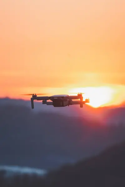Mobile drone at work during sunset. Technological innovation in photography and aviation. Aerial view video recording. Flying device.