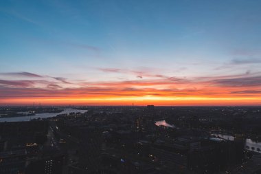 Hollanda 'nın Rotterdam kentindeki gece hayatının havadan görünüşü. Arka planda batan güneşten gelen kırmızı parıltı.