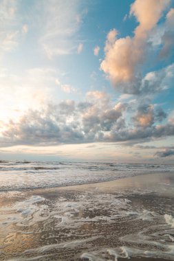 Hollanda, Zandvoort yakınlarındaki Kuzey Denizi kıyılarında nefes kesici bir gün batımı. Deniz yüzeyinin soyut görüntüsü ve renkli gökyüzü.