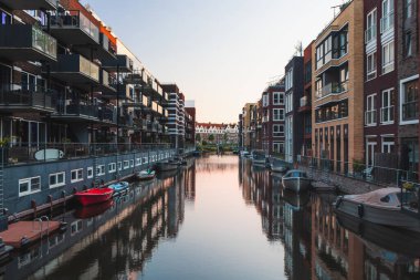 Binaları geçen kanalın su yüzeyine yansıyan renkli apartman blokları. Hollanda konutları. Ev hayatı..