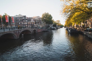 Günbatımı Hollanda 'nın başkenti Amsterdam' da bir su kanalı ve bitişik binaları aydınlatır. Kuzeyli Venedik.