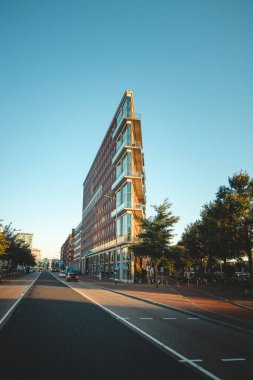 Amsterdam, Hollanda 'daki rıhtımdaki üçgen modern gökdelen. Gün batımında Hollanda mimarisi.