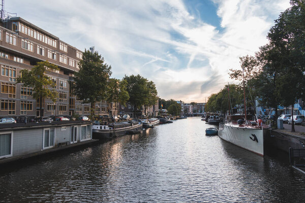 Sunset illuminates a water canal and adjacent buildings in the capital city of Amsterdam, the Netherlands. Venice of the North.