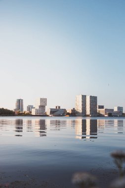 Hollanda 'nın Almere şehrinde gündoğumu sırasında gökdelen tasarımı. Hollanda modern inşaatı. Yeni bir günün şafağı. Arkaplanda süpernova.