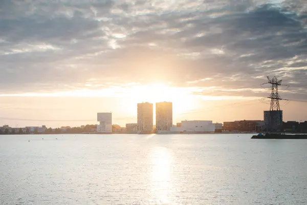 Hollanda 'nın Almere şehrinde gündoğumu sırasında gökdelen tasarımı. Hollanda modern inşaatı. Yeni bir günün şafağı. Arkaplanda süpernova.