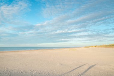 Belçika, Oostende yakınlarındaki bir sahilde dünyaya el sallayan bir adamın silueti. Atlantik Okyanusu kıyısındaki kumsallar.