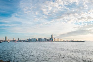 Günbatımı, Belçika 'nın Oostende kentindeki Atlantik Okyanusu kıyılarındaki gökdelenleri ve otelleri aydınlatır. Turizm beldesi.