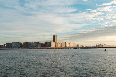 Günbatımı, Belçika 'nın Oostende kentindeki Atlantik Okyanusu kıyılarındaki gökdelenleri ve otelleri aydınlatır. Turizm beldesi.