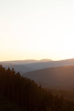 Çek Cumhuriyeti 'nin Beskydy dağlarındaki dağ ve yamaçlardan sabah saatlerinde güneş ışınları yayılıyor..
