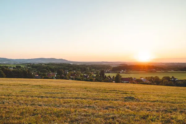 Frydek-Mistek, güneşten gelen turuncu-kırmızı ışıkla karanlık bir gökyüzüne karşı aydınlandı. Beskydy Dağları, Çek Cumhuriyeti.