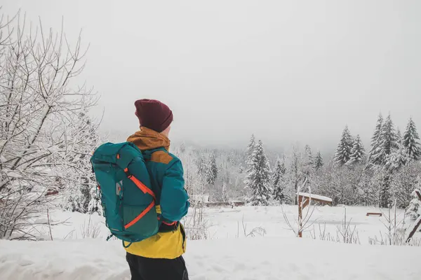 Traveller looks around the snowy landscape. Winter walk through untouched landscape in Beskydy mountains, Czech Republic. Hiking lifestyle.