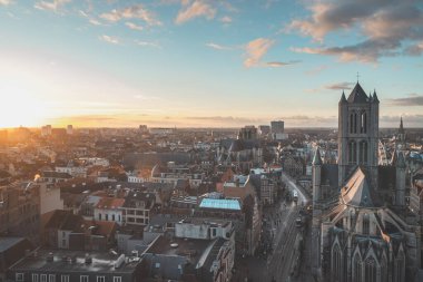 Şehrin merkezindeki tarihi kuleden Ghent 'te gün batımını izliyordum. Gökyüzünde romantik renkler. Gent 'i aydınlatan kırmızı ışık, Flanders bölgesi, Belçika.