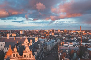 Şehrin merkezindeki tarihi kuleden Ghent 'te gün batımını izliyordum. Gökyüzünde romantik renkler. Gent 'i aydınlatan kırmızı ışık, Flanders bölgesi, Belçika.