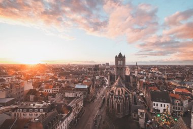 Şehrin merkezindeki tarihi kuleden Ghent 'te gün batımını izliyordum. Gökyüzünde romantik renkler. Gent 'i aydınlatan kırmızı ışık, Flanders bölgesi, Belçika.