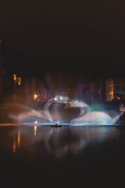 Belçika 'nın tarihi Bruges bölgesindeki su kanalında Kuğu Dansı şeklinde Noel ışığı gösterisi. Romantik sahne.