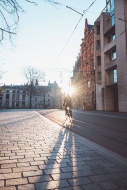 Ghent, Belçika 'nın şehir merkezinde güneş doğarken bisikletle işe koşan bir adam. Ana ulaşım aracı olarak bisikleti kullanın. Ekolojik mühendislik.